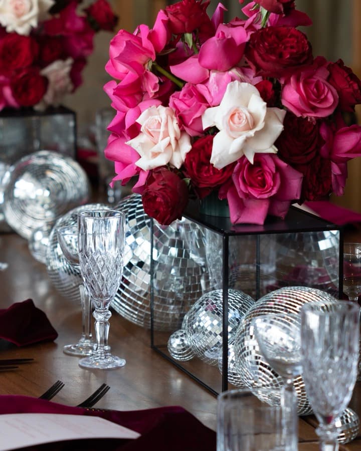 Close up of the table: roses, cut crystal glasses and burgundy napkins